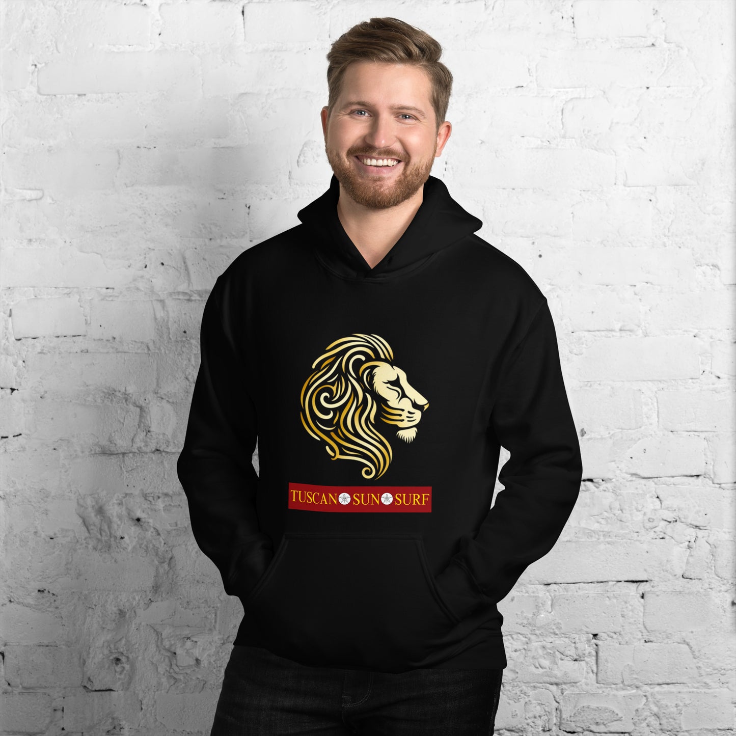 Man wearing a unisex black hoodie with a lion head in shades of yellow. Below the lion face is the Tuscan Sun Surf logo.