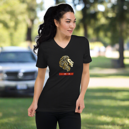 Woman wearing a black vneck unisex tshirt with a graphic design of a lion head in shades of yellow. Below the lion face is the Tuscan Sun Surf logo.